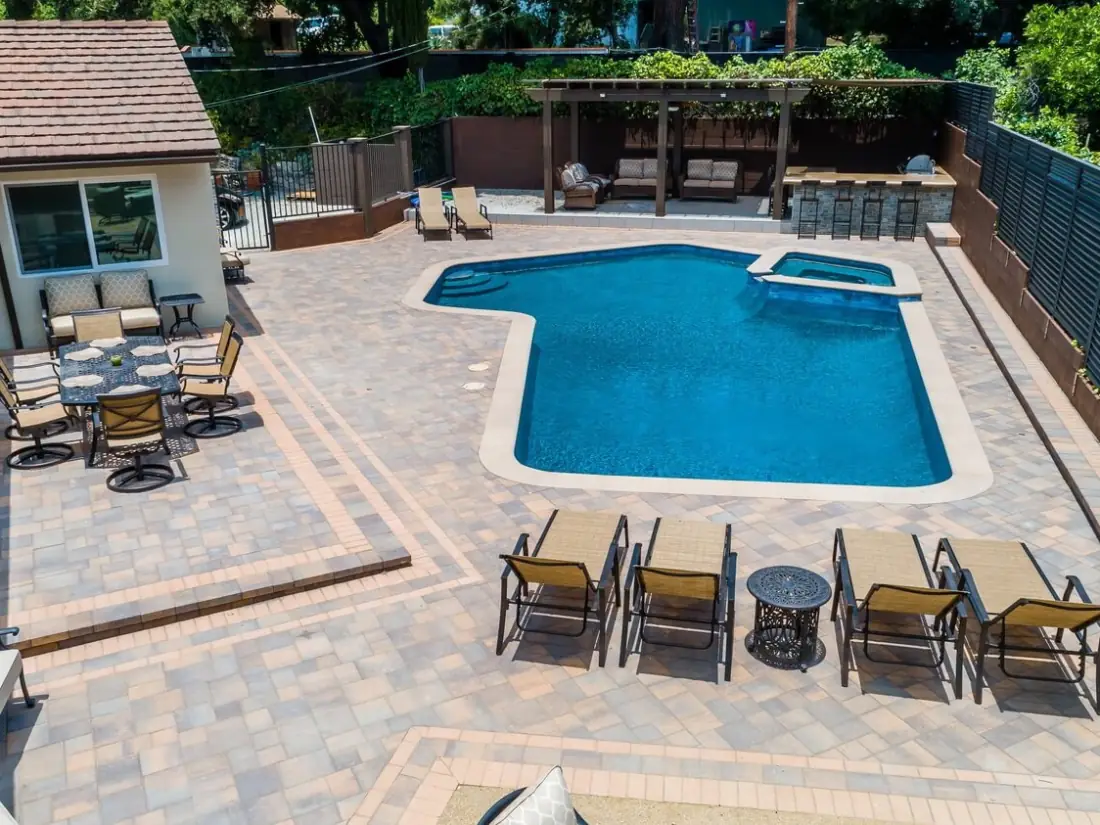 Altadena 1 Aerial view of a remodeled pool and spa with a paver deck, outdoor dining and lounge chairs