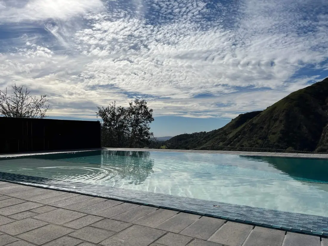 Malibu 1 Infinity-edge pool with a mosaic tile edge against the hills