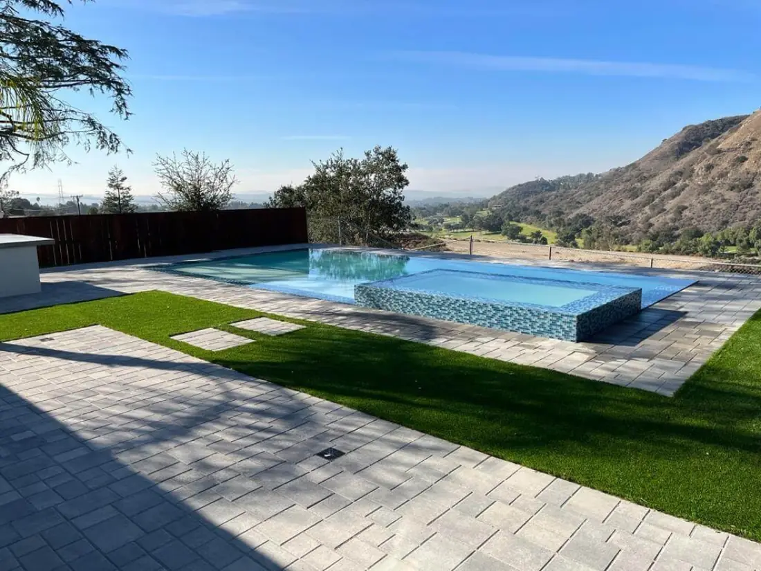 Agoura Hills 1 Infinity-edge pool with a glass tile spa, paver deck and turf overlooking the hills