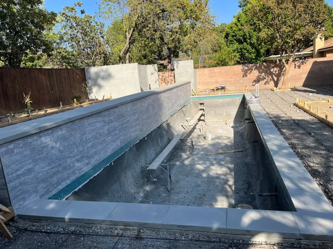 Granada Hills 2 New lap pool with a stacked-stone tile wall and coping, before plaster