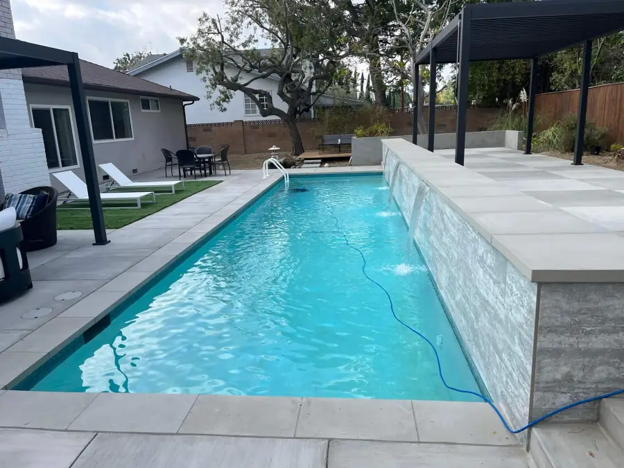 New lap pool with a stone water wall in a Granada Hills backyard