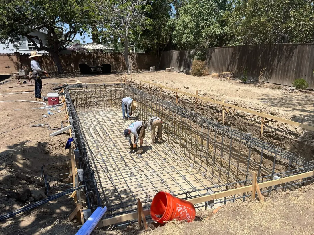 New Construction of Pools 2 Crew tying rebar in a rectangular pool excavation