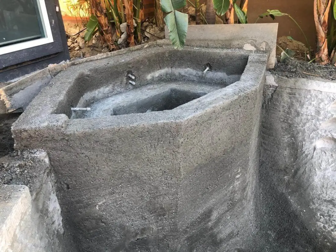 Newly sprayed gunite shell for a spa in a narrow side yard