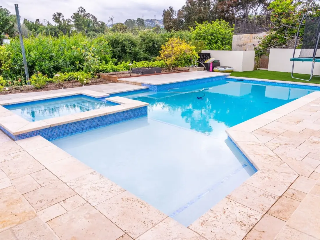 Encino 1 Pool and spa with a travertine deck, coping and glass tile trim