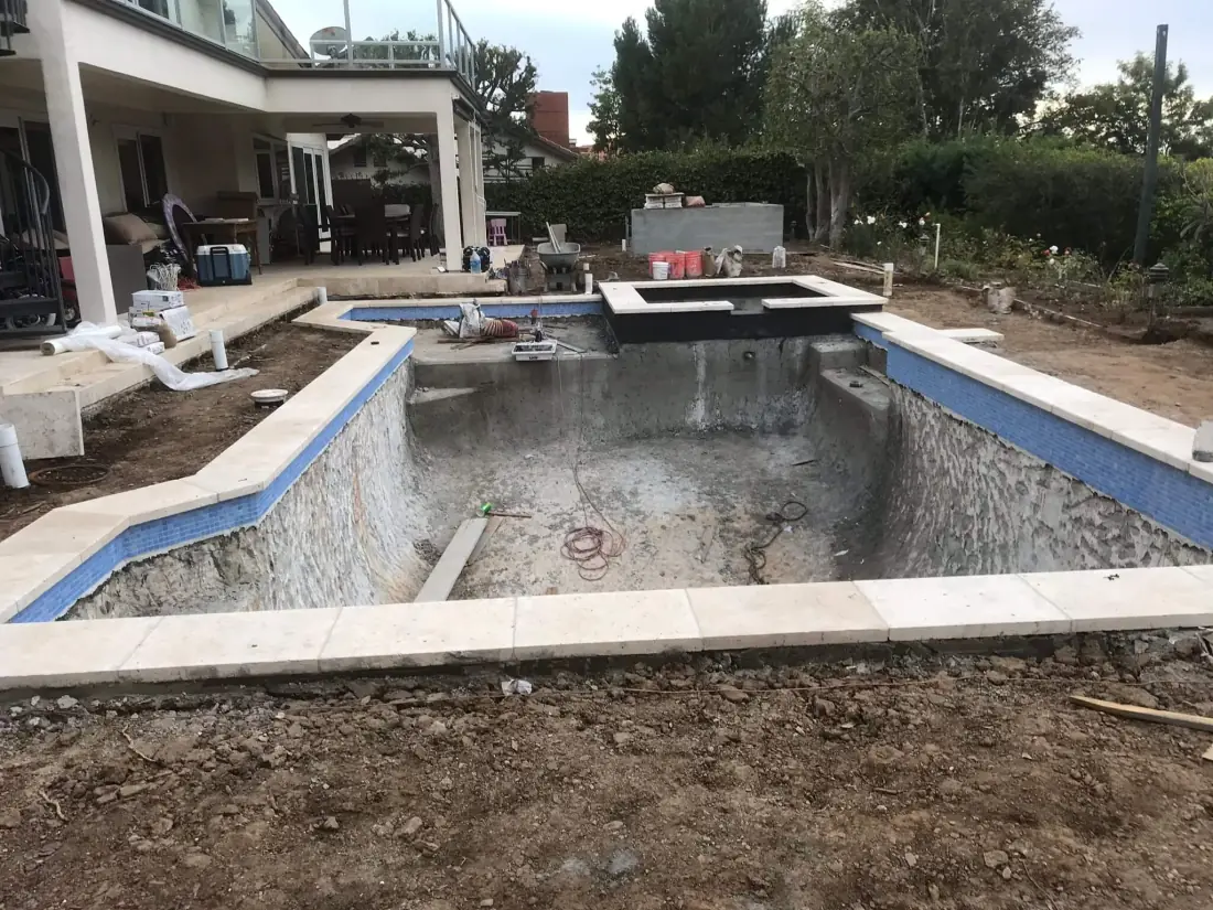 Encino 2 Pool remodel in progress with new coping and waterline tile around the stripped shell