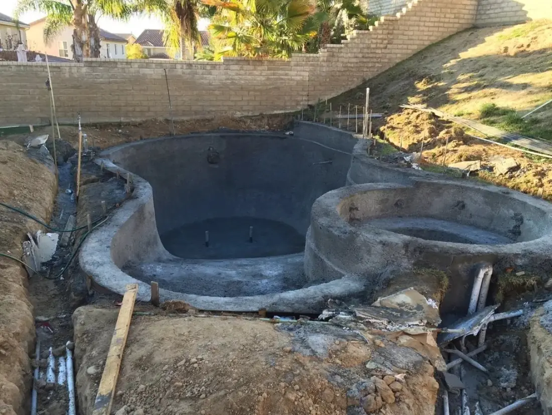 Pool Equipment Repair 2 Gunite pool and spa shell with plumbing lines stubbed up through the dirt beside it