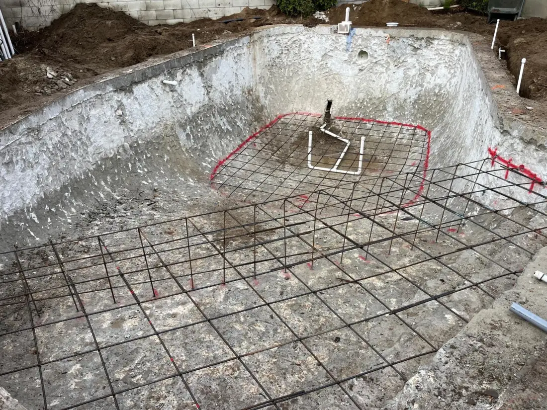 Toluca Lake 1 Rebar laid over an existing pool shell for a rebuild, with the new layout marked in red