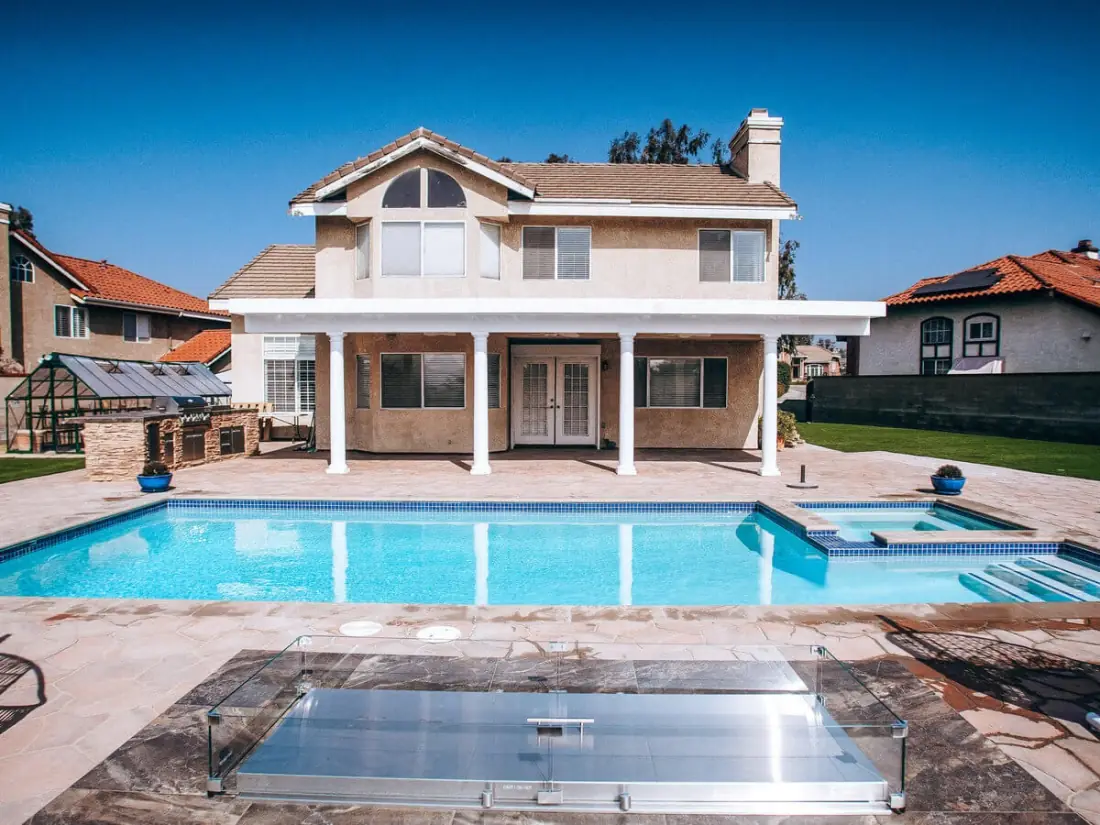 Valley Village 1 Rectangular pool and spa behind a two-story house with a flagstone deck