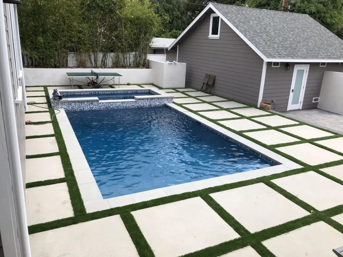Pasadena 1 Rectangular pool with a glass tile raised spa and concrete pavers set in turf