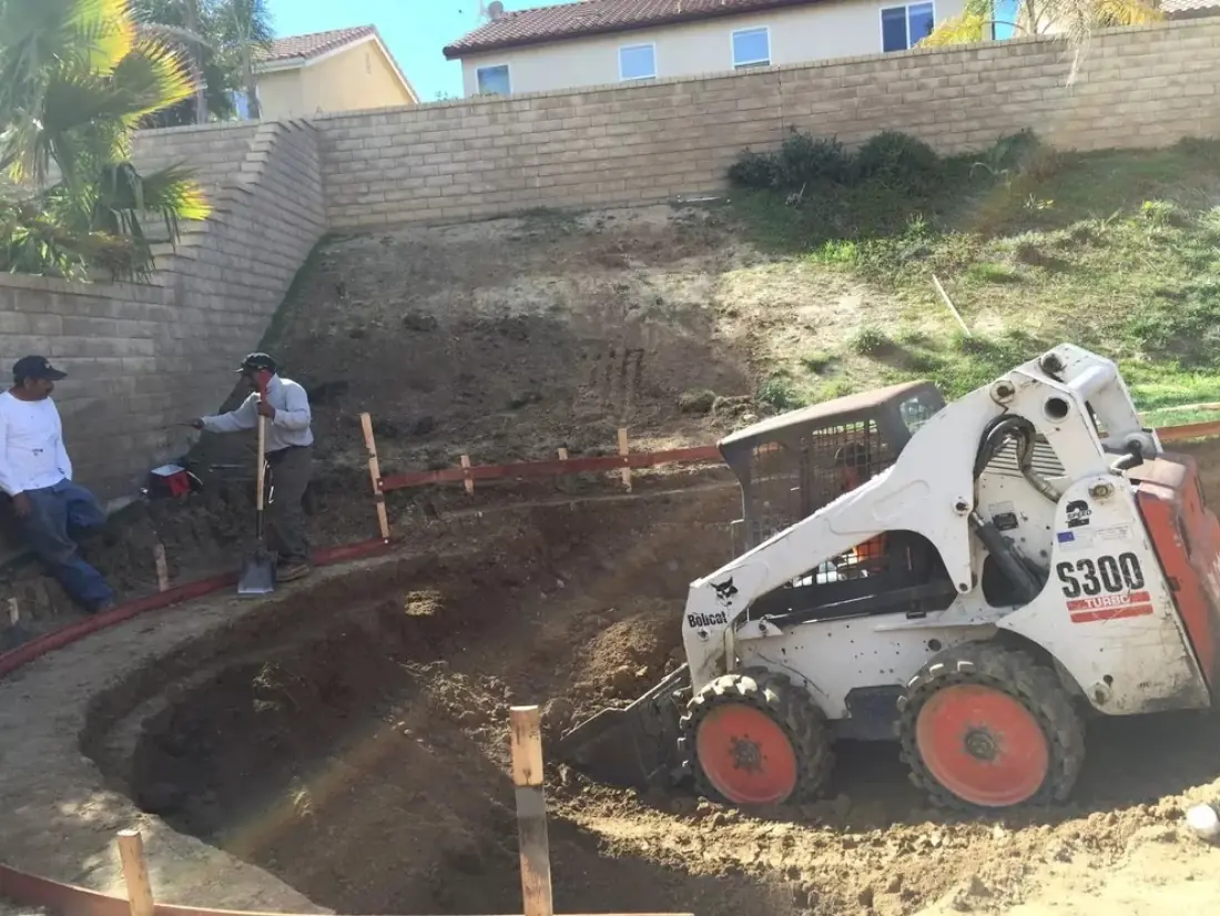 Reseda 2 Skid steer excavating a new pool in a sloped backyard