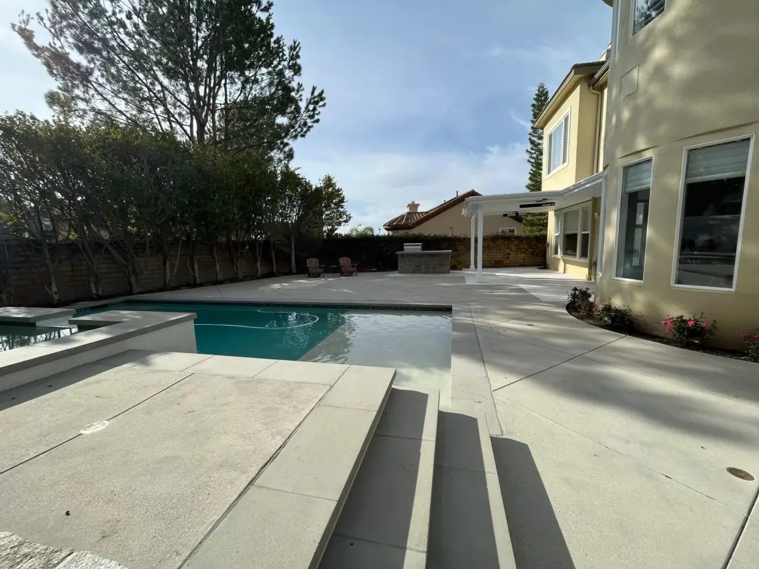 Oak Park 1 Wide concrete steps and deck leading down to a pool and spa